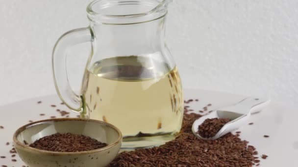 Flax seeds and Flax oil. Glass bottle of flax oil. — Stock Video