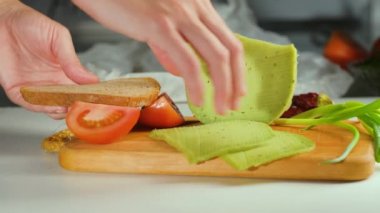 Yeşil peynirli sandviç hazırlayan kadınlar.