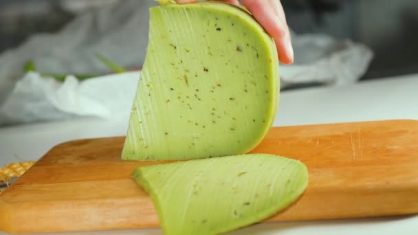 Primer plano de la mujer cortando queso verde con hierbas y especias. — Vídeo de stock