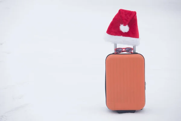 Valigia Arancione Con Occhiali Sole Cappello Babbo Natale Sulla Neve — Foto Stock
