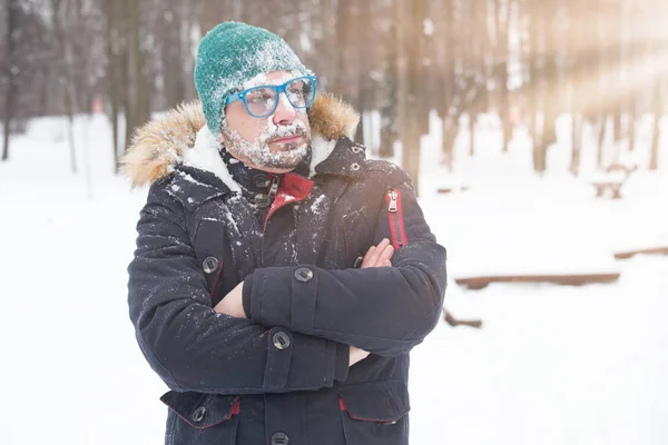 Portrait of male face covered with snow. Crazy, cheerful, funny, comic and emotions