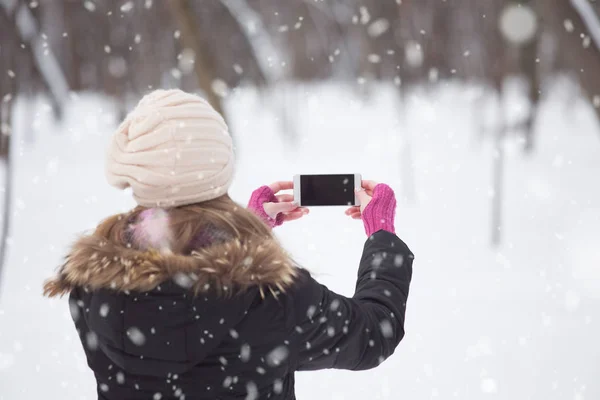 Tampilan Belakang Gadis Pada Hari Salju Memegang Layar Kosong Smartphone — Stok Foto