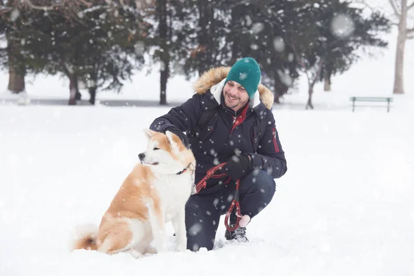 Молодой Человек Собакой Акита Парке Снежный День — стоковое фото