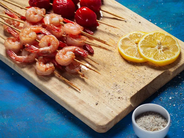 Pişmiş ızgara karides ve domates. Deniz ürünleri. Baharatlar ve limon ile karides. Karides kebap. Barbekü karides