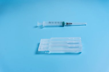 Aşı üzerinde mavi arka plan ile şırınga