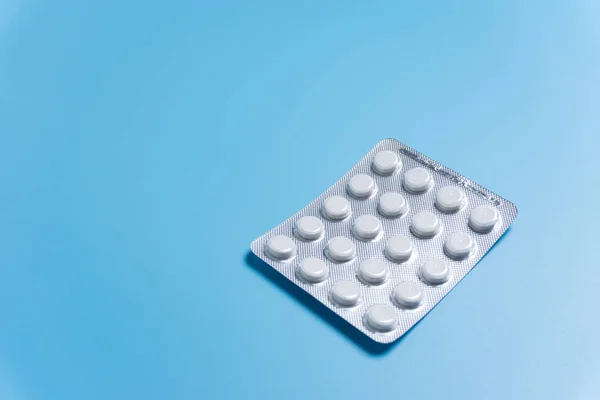Pills in pack on blue background