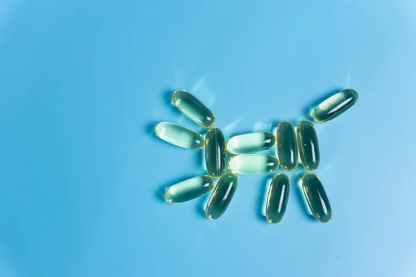 Mavi arka planda balık yağı kapsülleri