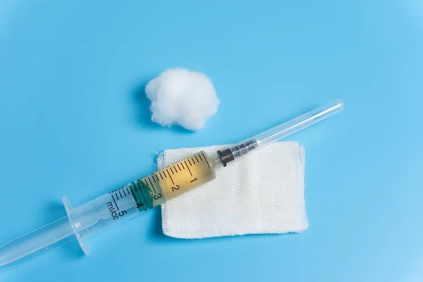 Aşı üzerinde mavi arka plan ile şırınga