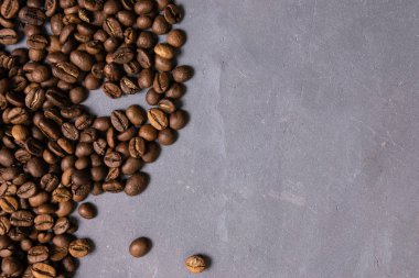 Kavrulmuş kahve çekirdekleri dökme gri beton zemin üzerine. karanlık