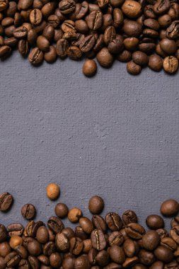 Kavrulmuş kahve çekirdekleri dökme gri beton zemin üzerine. karanlık