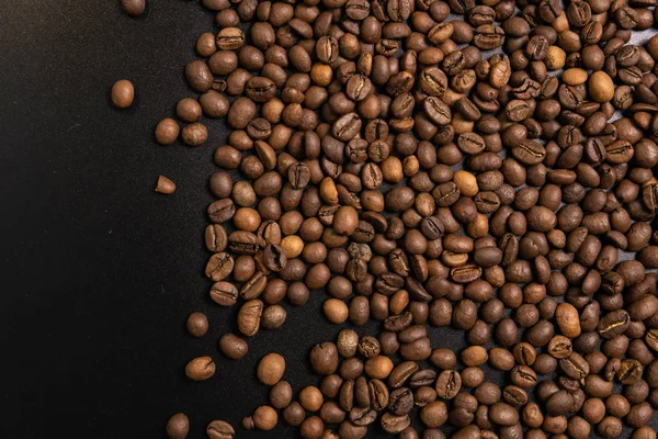 Жареный кофе в зернах оптом на черном фоне. темный кофеин r — стоковое фото