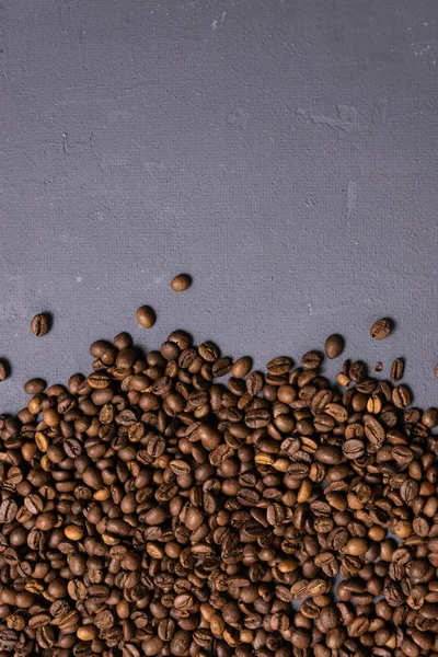 Жареный кофе в зернах оптом на сером бетонном фоне. темные — стоковое фото