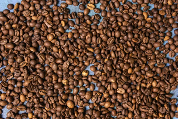 Granos de café tostados a granel sobre fondo azul — Foto de Stock