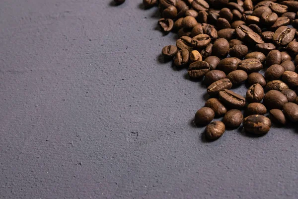 Жареный кофе в зернах оптом на сером бетонном фоне. темные — стоковое фото