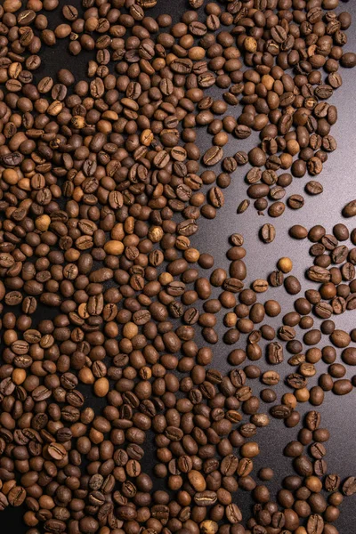 Roasted coffee beans in bulk on a black background — Stock Photo, Image