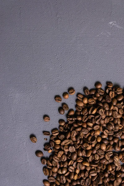 Kavrulmuş kahve çekirdekleri dökme gri beton zemin üzerine. karanlık
