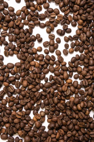 Roasted coffee beans in bulk on a light blue background