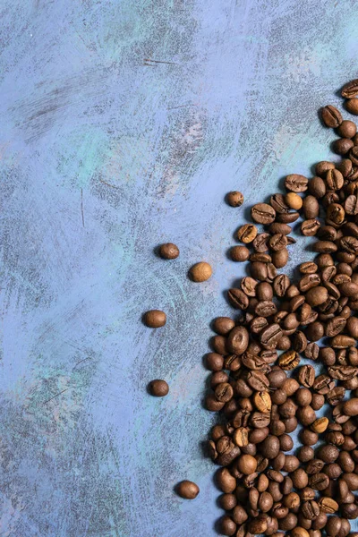 Kavrulmuş kahve çekirdekleri mavi bir arka plan üzerinde toplu olarak. koyu kahve ro