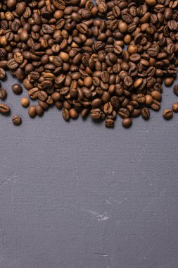 Kavrulmuş kahve çekirdekleri dökme gri beton zemin üzerine. karanlık