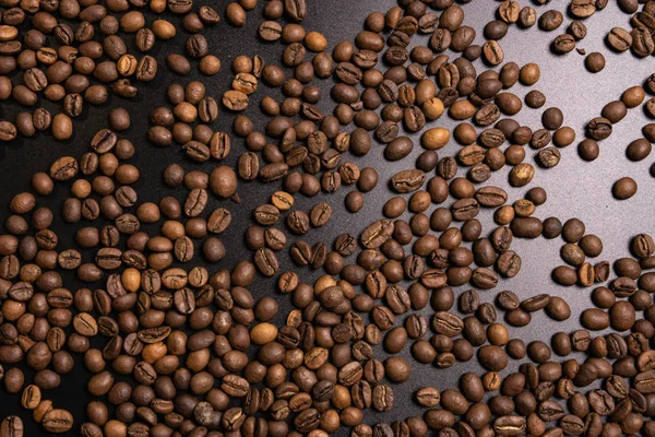 Granos de café tostados a granel sobre fondo negro — Foto de Stock