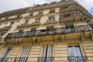 Paris 'te büyük pencerelere ve çiçeklerle donatılmış balkonlara sahip bina 