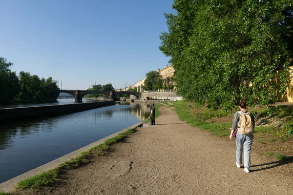 La chica está caminando por el camino entre el río y el tre — Foto de Stock