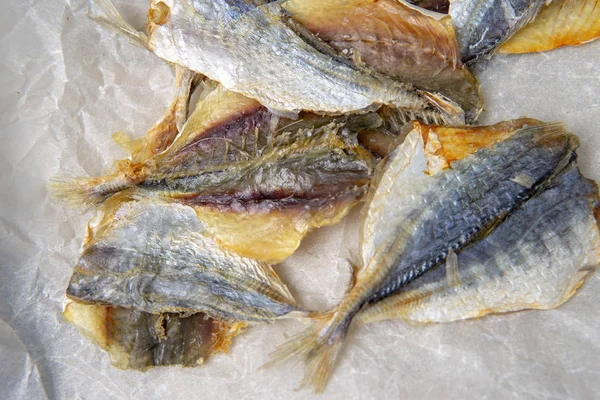 Αλατισμένα ψάρια βρίσκονται σε ξεδιπλωμένη χαρτί. — Φωτογραφία Αρχείου