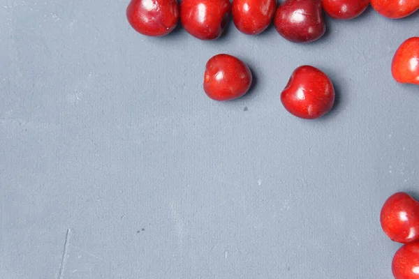Kırmızı tatlı kiraz gri bir arka planda dağılmış