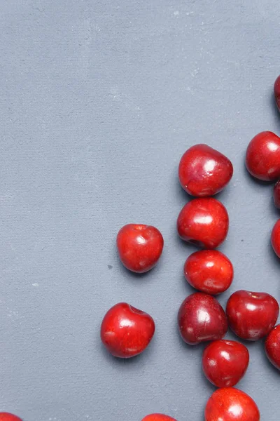 Kırmızı tatlı kiraz gri bir arka planda dağılmış