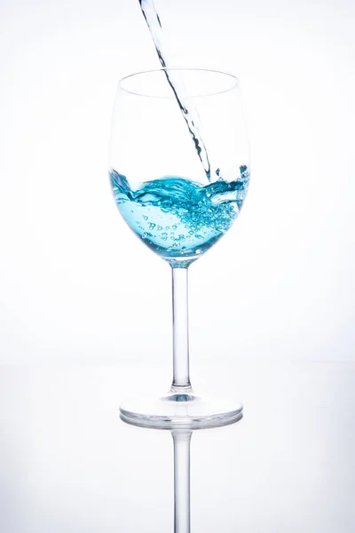 Coquetel azul é derramado em um copo em um fundo branco com — Fotografia de Stock