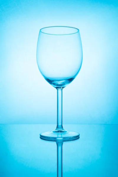 Verre à vin vide avec réflexion dans la lumière bleue — Photo