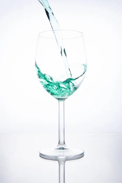 Grüner Cocktail wird in ein Glas auf weißem Hintergrund gegossen mit — Stockfoto
