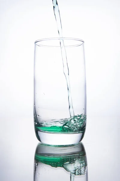 Green cocktail is poured into a glass on a white background with — Stock Photo, Image