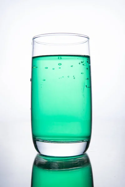 Groene cocktail in een glas op een witte achtergrond met reflectie — Stockfoto