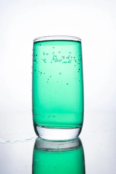Зелений коктейль у склянці на білому тлі з відображенням — стокове фото