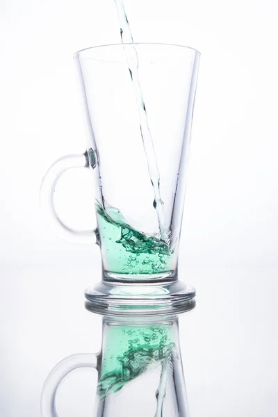 Green cocktail is poured into a glass on a white background with — Stock Photo, Image