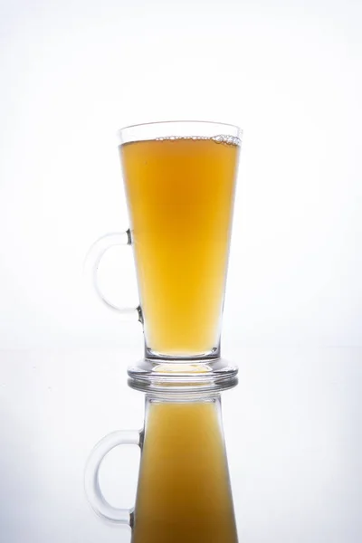 Leichtes ungefiltertes Bier, das in einen dampfenden Becher auf weißem Rücken gegossen wird — Stockfoto