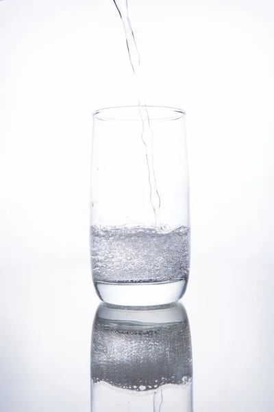 Das Glasbecherglas ist mit klarem, transparentem Mineralwasser gefüllt. — Stockfoto