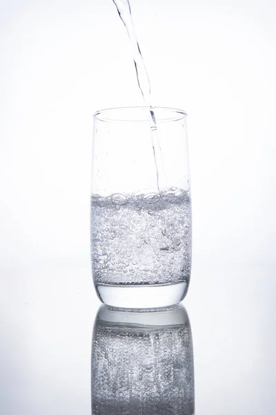 Das Glasbecherglas ist mit klarem, transparentem Mineralwasser gefüllt. — Stockfoto