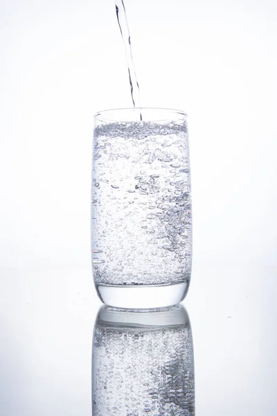 Das Glasbecherglas ist mit klarem, transparentem Mineralwasser gefüllt. — Stockfoto