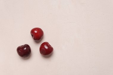Krem arka planda dağınık kırmızı tatlı kiraz