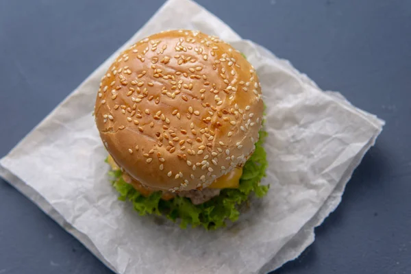 Burger with beef patty, salad, a slice of tomato and cheese, oni — Stock Photo, Image