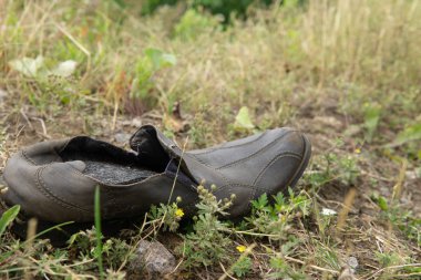 Çimenlerde yatan terk edilmiş deri çizme
