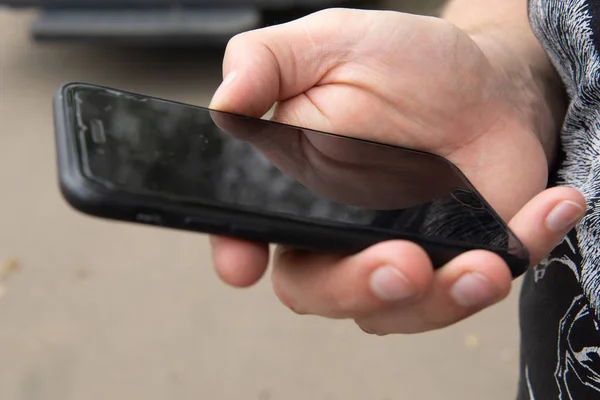 Erkek elinde siyah cep telefonu