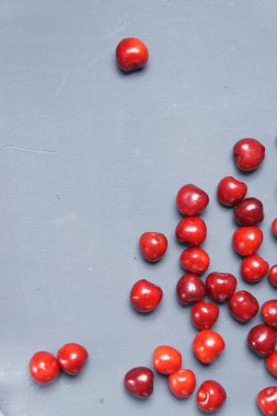 Kırmızı tatlı kiraz gri bir arka planda dağılmış