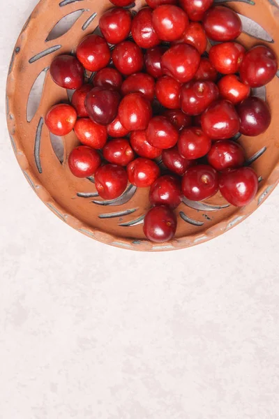 Red sweet cherry in a clay plate on a cream table — Stock Photo, Image