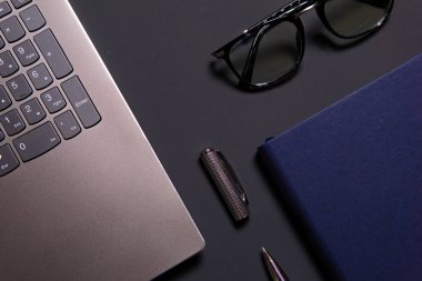 Dizüstü bilgisayar, dizüstü bilgisayar, gözlükler ve kalem masada. İş veya çalışma kavramı.