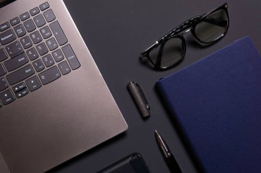 Dizüstü bilgisayar, dizüstü bilgisayar, gözlükler ve kalem masada. İş veya çalışma kavramı.
