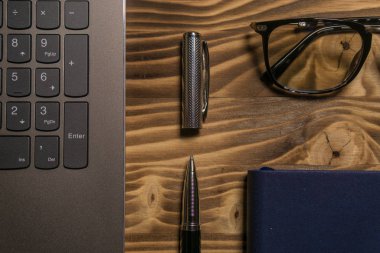 Dizüstü bilgisayar, dizüstü bilgisayar, gözlükler ve kalem masada. İş veya çalışma kavramı.