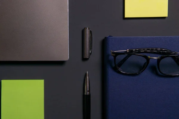 Dizüstü bilgisayar, dizüstü bilgisayar, gözlükler ve kalem masada. İş veya çalışma kavramı.